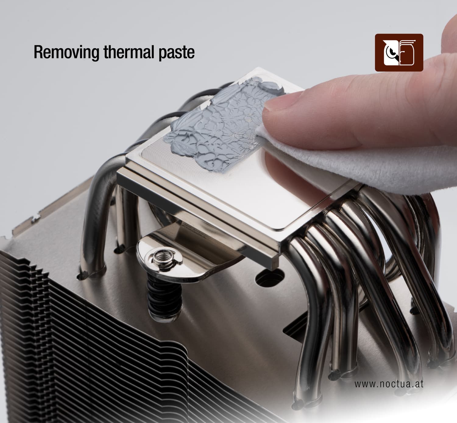 A cleaning wipe is used to remove thermal paste from a cooler base