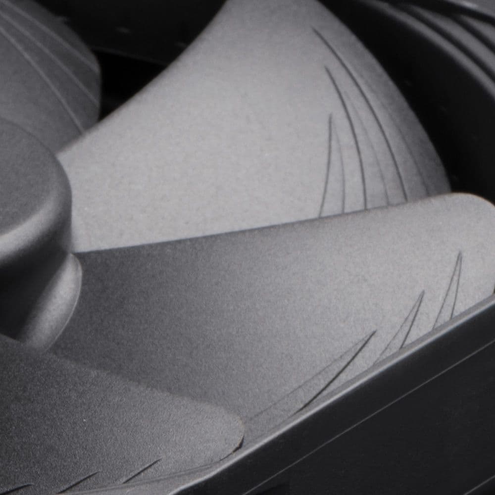 Close-up of matte black Noctua fan blades, showing the textured surface and distinctive stepped inner edges for airflow optimization.