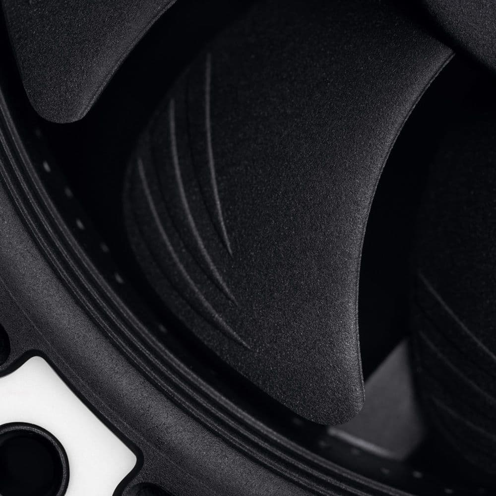 A close-up of a matte black Noctua NF-A9x14 fan blade, highlighting the textured surface and Flow Acceleration Channels.