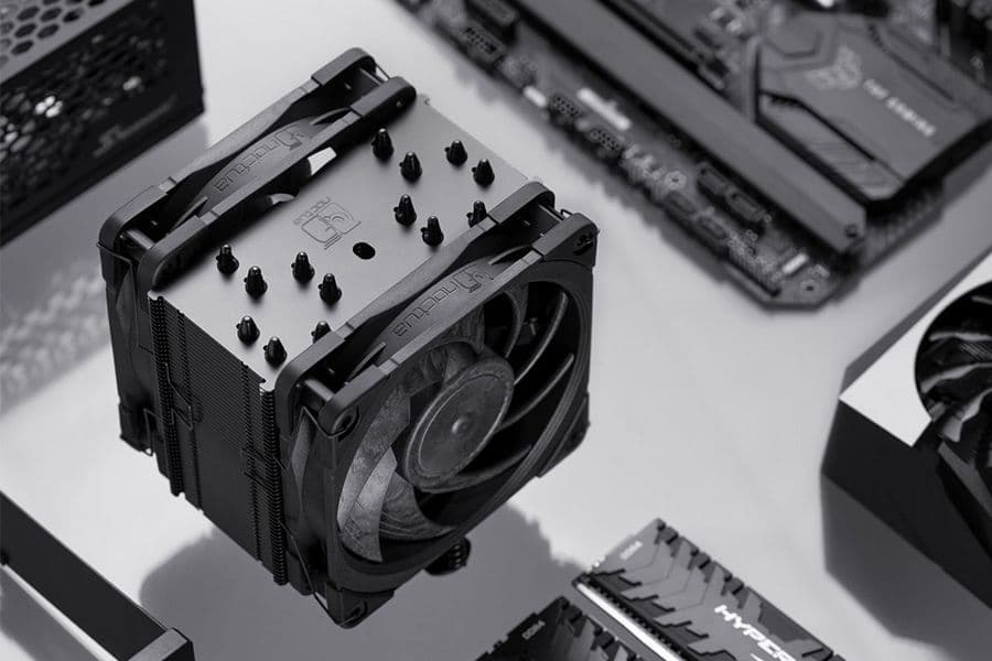 Close-up of a black Noctua NH-U12A chromax.black CPU cooler surrounded by PC components like RAM and motherboard.