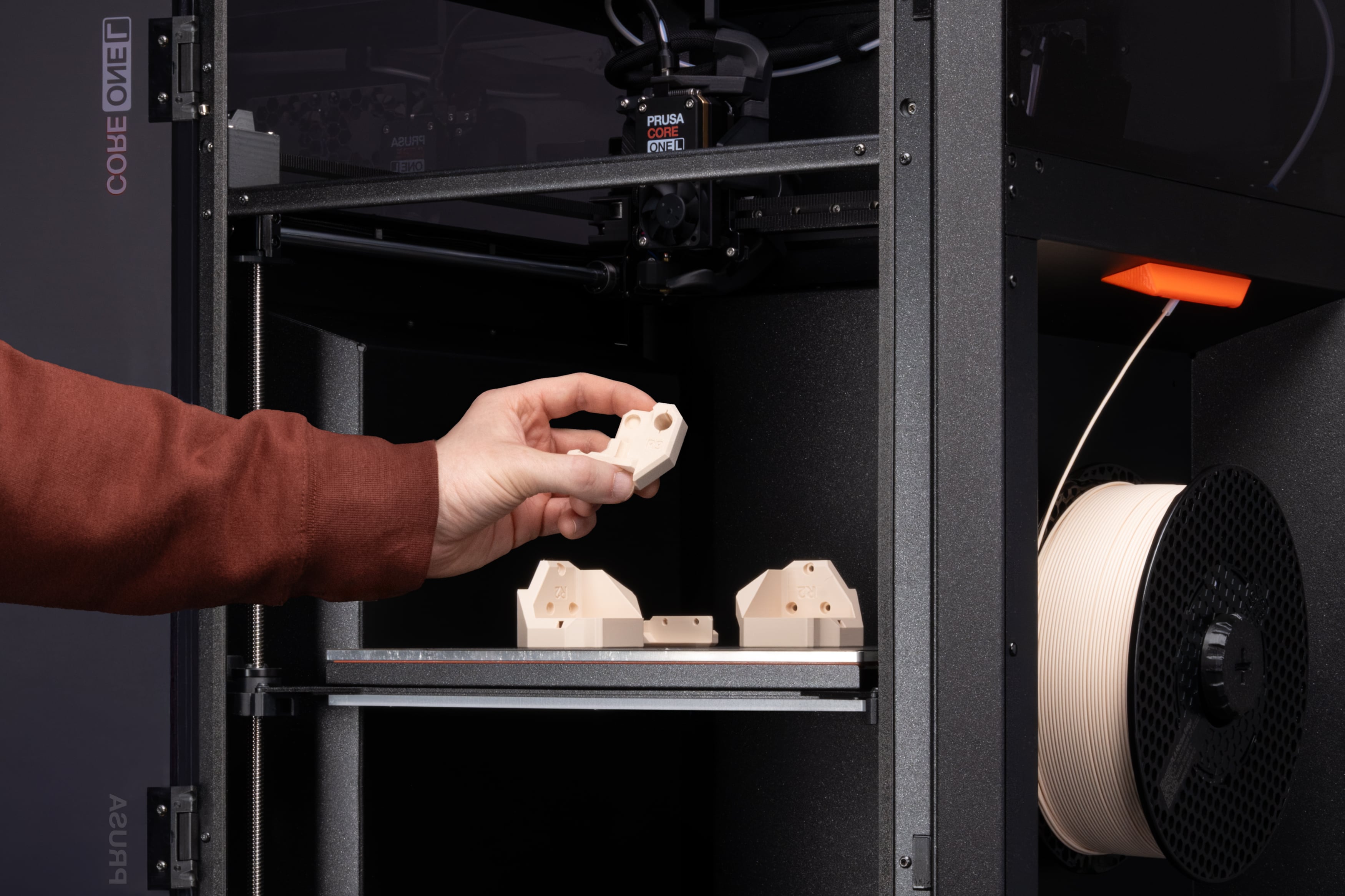 Beige 3D printed parts inside the Prusa CORE One L printer