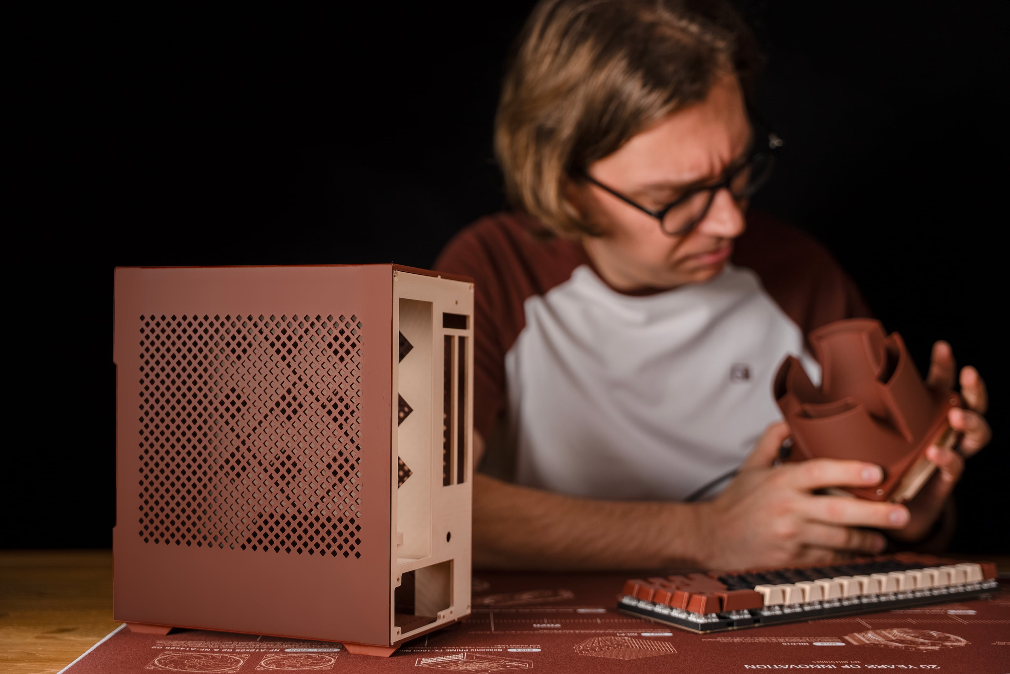 Person inspecting 3D printed airflow amplifier with 3D printed case and keyboard in the foreground