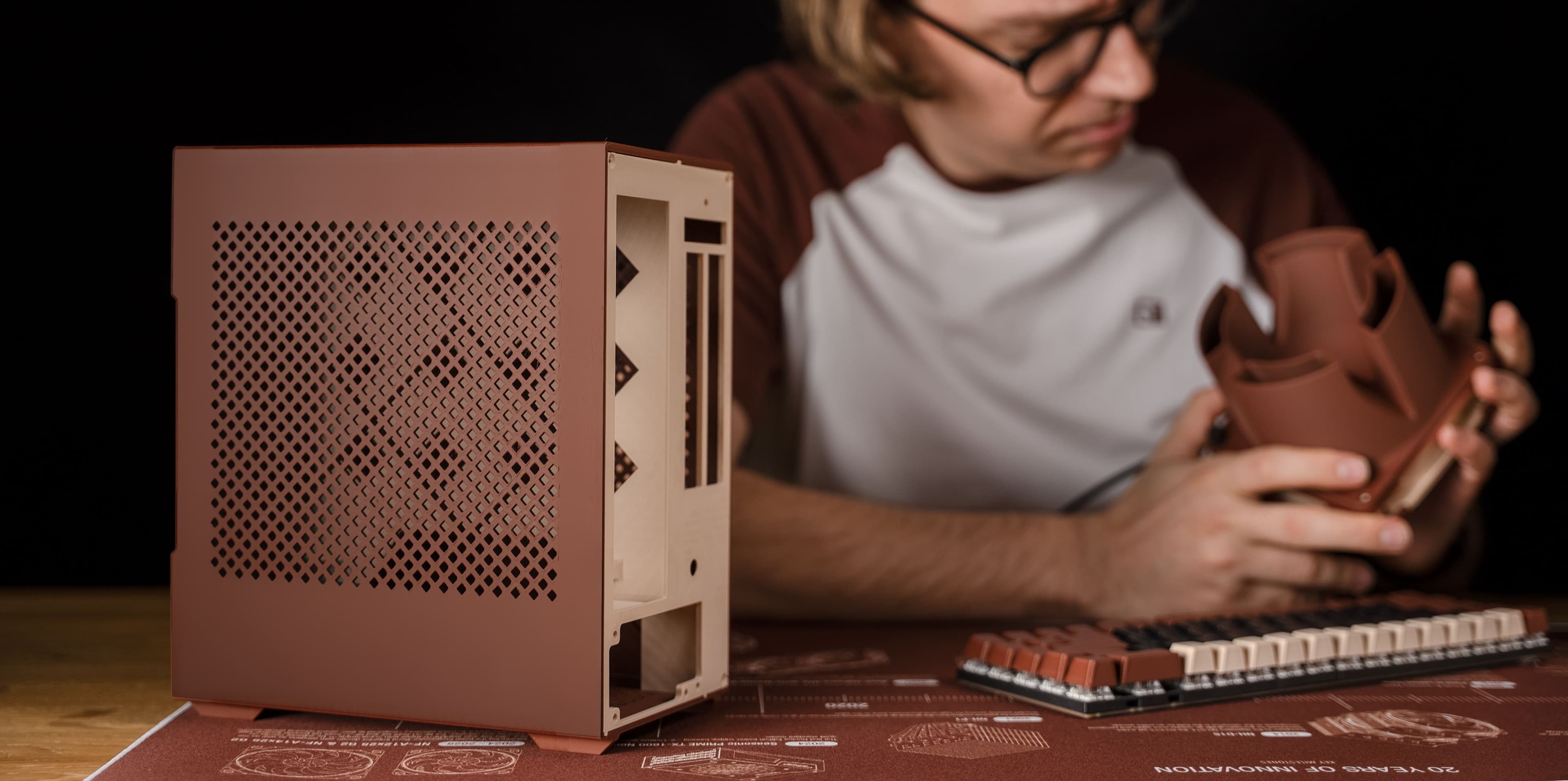 Man inspects a 3D printed airflow amplifier next to a 3D printed case and 3D printed key caps